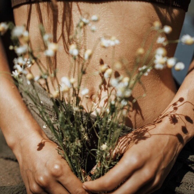 llustration of a woman holding her lower belly, symbolizing womb healing and feminine energy.