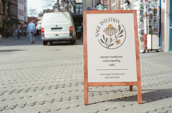 Image for 5 signs you need a rebrand blog. Image of Sage Intuition sandwich board. Cream with floral circular logo.