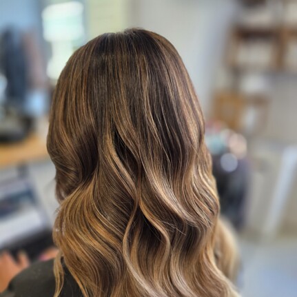 A long wavy brunette golden balayage by Hair by Shiyee.