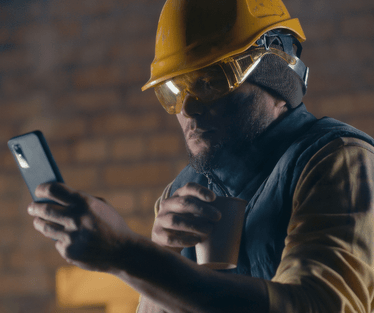 Tradie on site checking phone for messages or job info