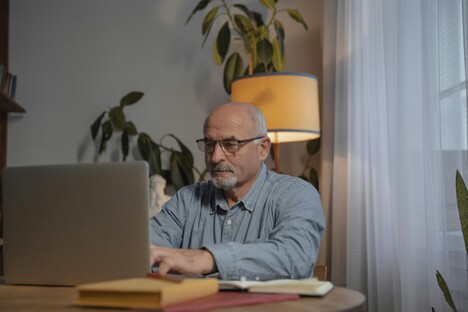 Tradie at desk with laptop and paperwork