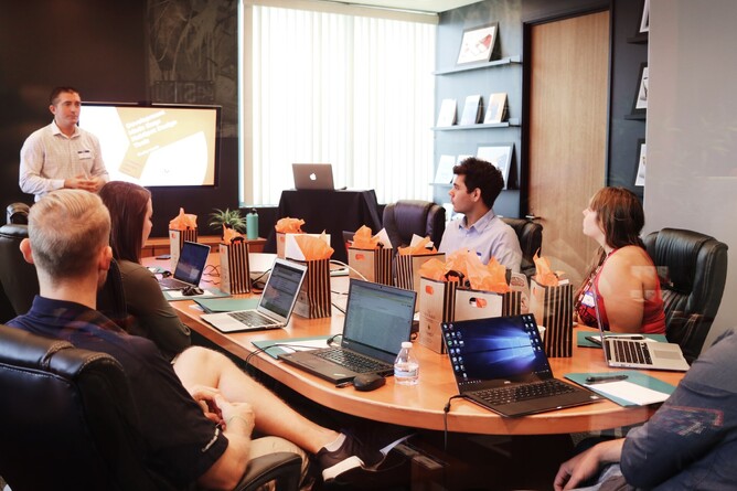 A group sitting at a table listening to a pitch