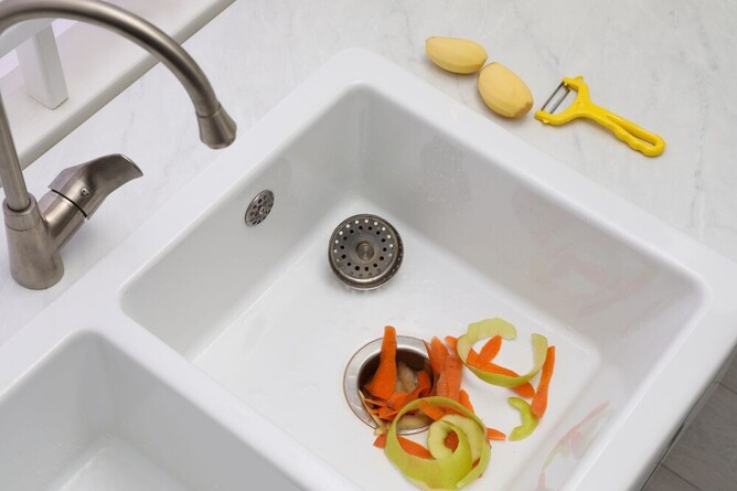 waste food disposal unit with food scraps in sink