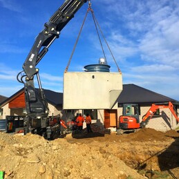 septic tank being lifted into place by crane