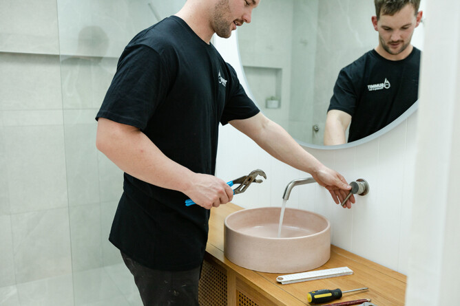 Plumber testing water pressure