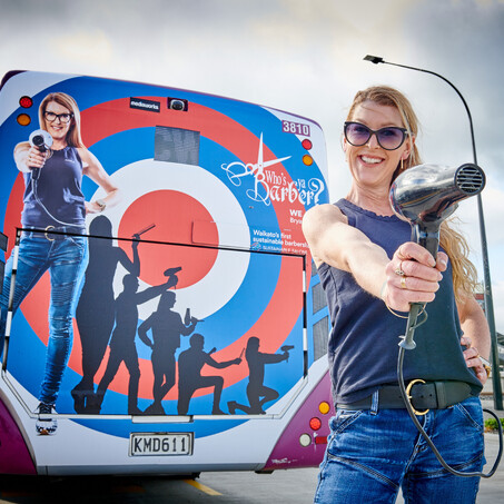 Craig Brown Photographer's image of who's your barber advert on back of bus and owner standing beside it