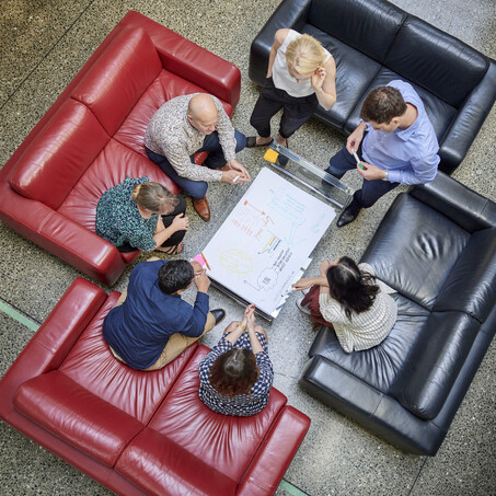 Craig Brown Photographer's arial image of a group of people sitting on couches discussing a plan 
