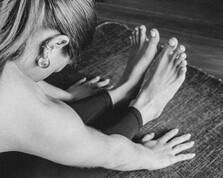 A person in the seated forward fold, or Paschimottanasana, position