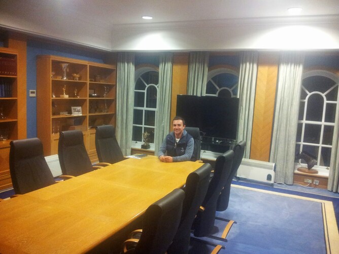 At the head of Shadwell's boardroom table surrounded by bookcases full of trophies. The TV behind me is for Sheikh Hamdan to take part in meetings