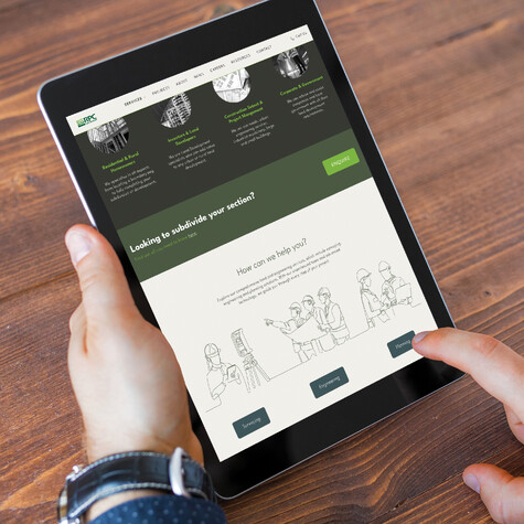 A person holds a tablet displaying the RPC website, showing services like surveying and planning, with a clean design and green accents