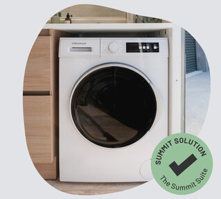 A white washing machine with a black glass door in a portable bathroom.