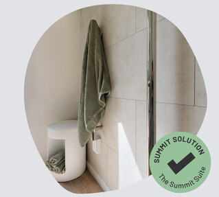 Vertical heated towel rails with green towels. 