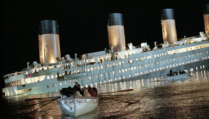 Photo of a ship sinking into the ocean, with people escaping on lifeboats