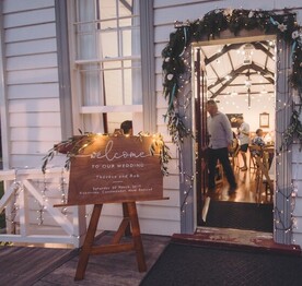 An illuminated sign outside the front door of the Kūaotunu Hall announcing the wedding reception being held inside