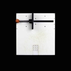 This is a square opacque white perspecs board, standing upright on one edge. It features a clamp device with a round red knob handle and a black clamp device at one side of the board. At the opposite end of the board are central group of nine spikes. The board is centrally positioned on a square black background.