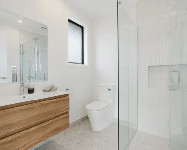 Image of modern neutral ensuite with timber cabinetry and pale grey tiling in Collinson Street, Pirongia new home, by Waikato residential builders Whitechurch Construction Limited.