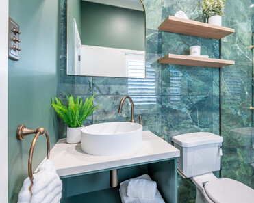 Image of newly renovated heritage bathroom in deep sage & white. Oval mirrors and round basins. Renovated by local Te Awamutu residential builders, Whitechurch Construction.