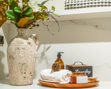 Close up image of laundry accessories and foliage in newly renovated heritage laundry room in deep sage & white. Renovated by local Te Awamutu residential builders, Whitechurch Construction.