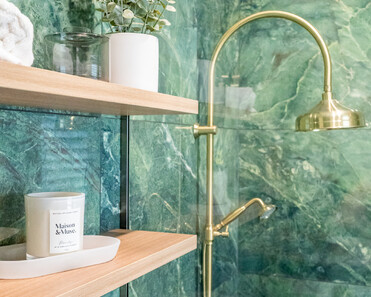 Close up image of brass shower head in green marble tiled shower in renovated heritage bathroom. Renovated by local Te Awamutu residential builders, Whitechurch Construction.