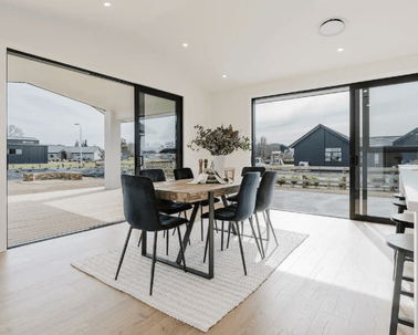 Image of natural light filled dining area with modern table and chair styling in Collinson Street, Pirongia new home, by Waikato residential builders Whitechurch Construction Limited.