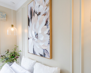 Image of newly renovated guest double bedroom in sand. Large floral print on the wall. Renovated by local Te Awamutu residential builders, Whitechurch Construction.