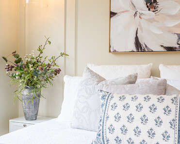 Image of newly renovated guest double bedroom in sand. Double bed styled with greys & white decorative pillows. Renovated by local Te Awamutu residential builders, Whitechurch Construction.