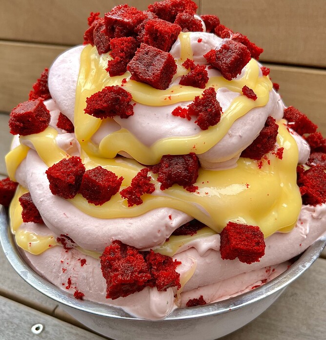 Our homemade Fresh Strawberry & Snowy Cheesecake Gelato is generously intertwined with big chunks of Rudolph's super moist Red Velvet Cake, and luscious White Chocolate Fudgey Wudgey Sauce.
