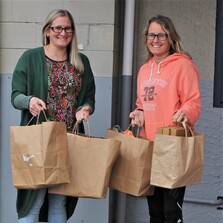 Two women holding bags of donated goodies