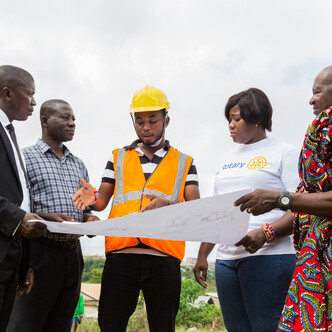 A group of people standing around a construction plan